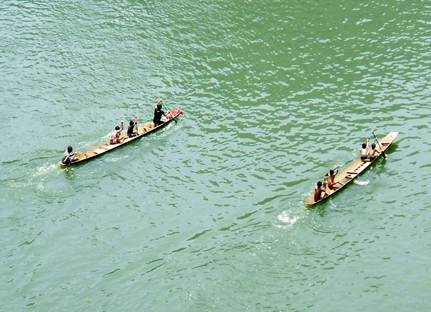 Children rowing paddle boats on Nam Oo river