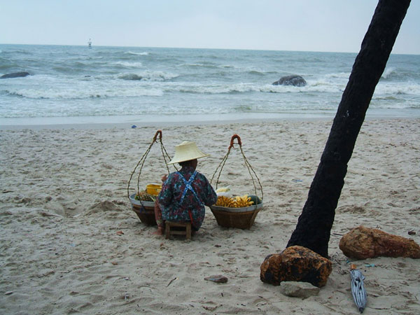 An old lady selling fruits on the beach