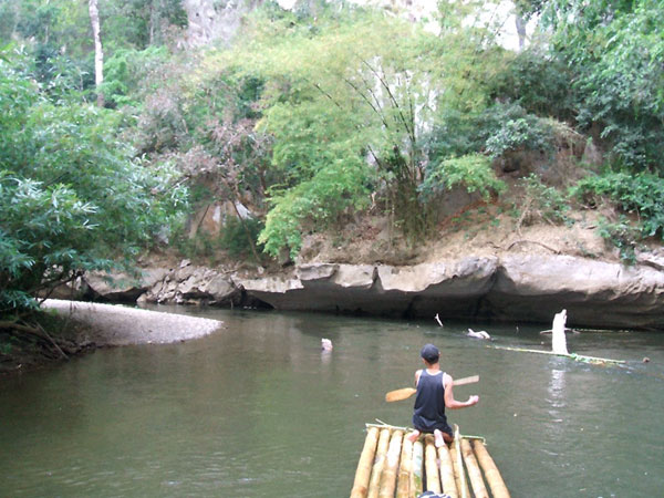 A Karen hilltribe man padding the bamboo raft on Mae Klong river, Umphang